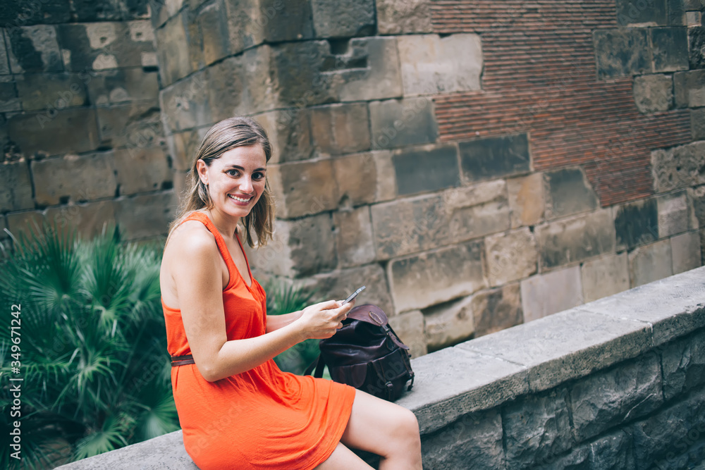 Cheerful traveling woman using smartphone in city Cheerful traveling woman using smartphone in city