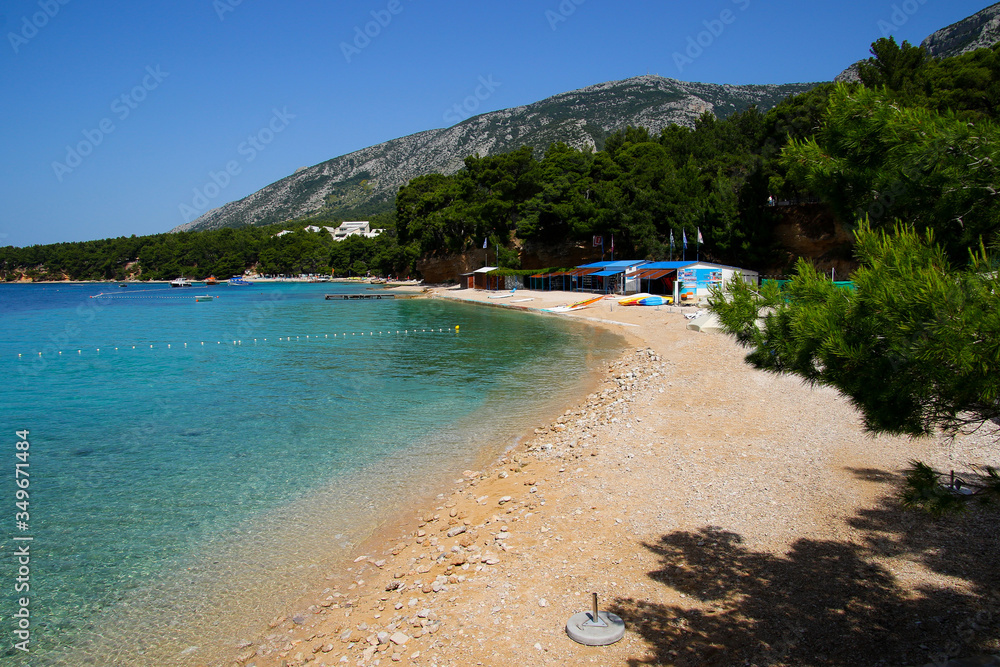 Small beach on the island of Brac in Croatia, near Bol - Seaside restaurants and swimmers in the Adriatic Sea