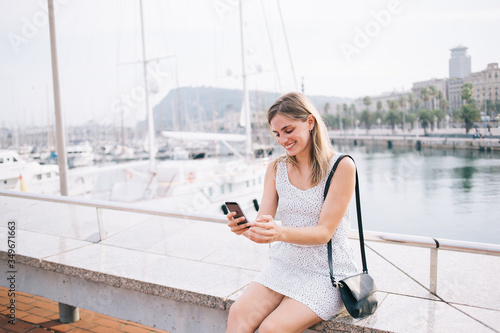 Joyful female tourist having video call via smartphone on city promenade © GalakticDreamer