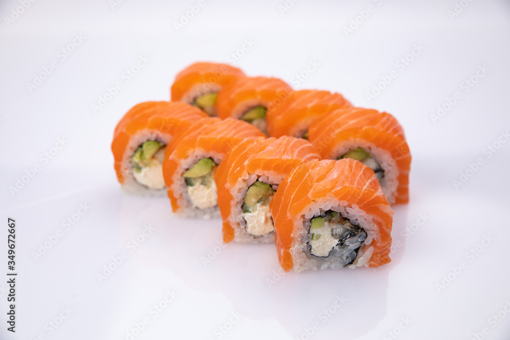Japanese cuisine. Sushi roll with salmon on white background. Japanese cuisine. Sushi roll with salmon on white background.