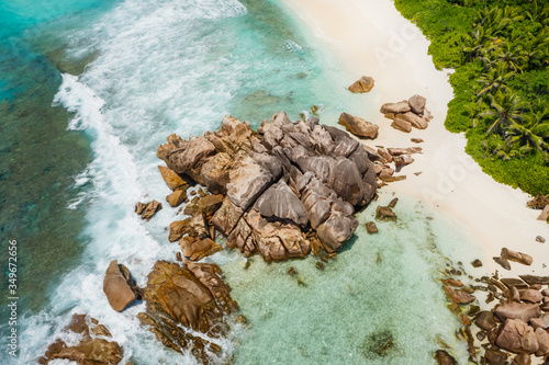 Seychelles La Digue Island. Aerial view of ocean waves and huge granite rocks on the tropical beach anse cocos with turquoise azure water. Holiday vacation destination photo