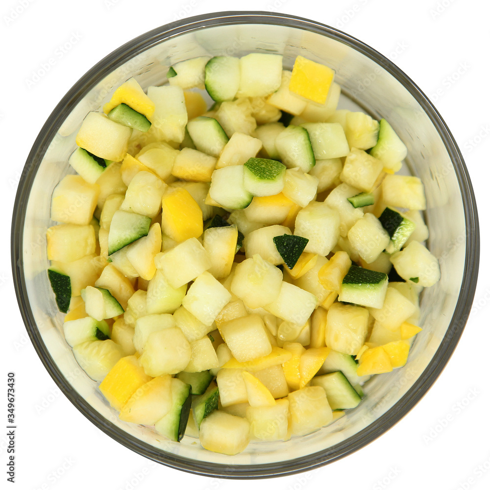 Bowl of chopped yellow squash and zucchini in glass bowl over white. Bowl of chopped yellow squash and zucchini in glass bowl over white.