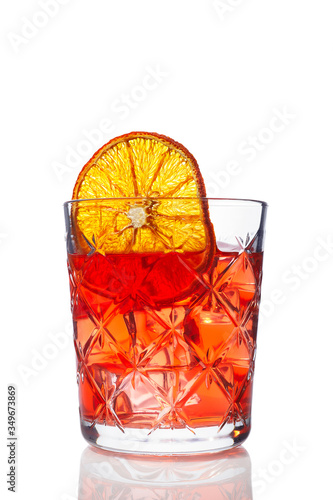 Glass of Campari-based cocktail with ice and an orange slice on a white background