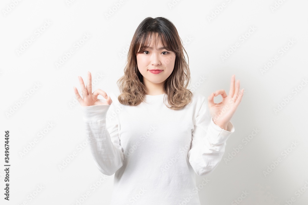 OKサインをポーズをする若い女性