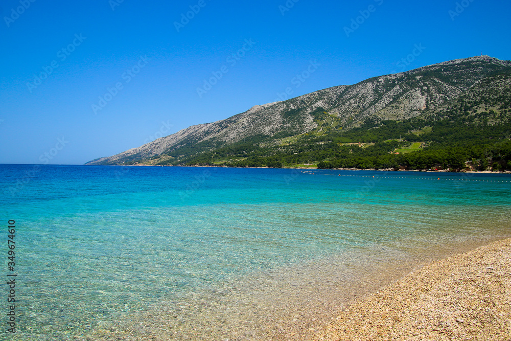 Beautiful beach on the Zlatny Rat peninsula near Bol on the island of Brac in Croatia - Turquoise transparent waters of the Adriatic Sea in summer