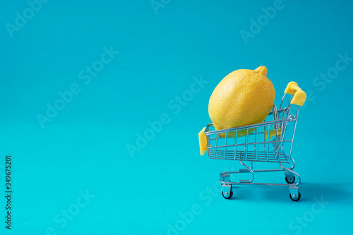 Lemon in the shopping trolley, vitamins. Health and vitaminization. Minimalism. photo