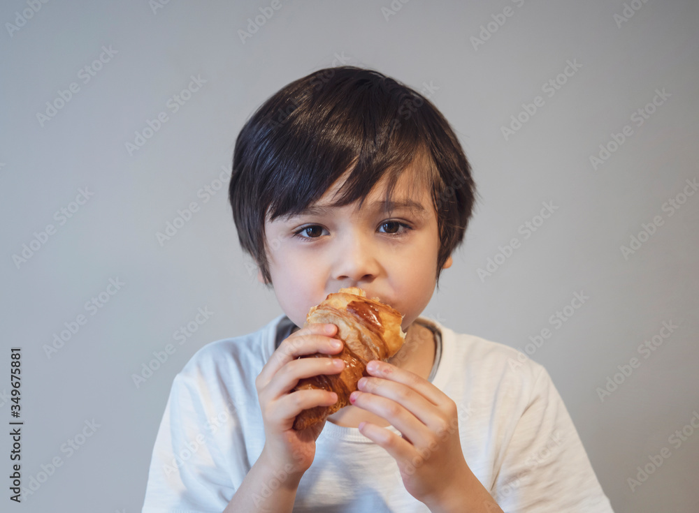 Child boy croissant for his breakfast before go to school in the morning, Healthy food for kid concept Child boy croissant for his breakfast before go to school in the morning, Healthy food for kid concept
