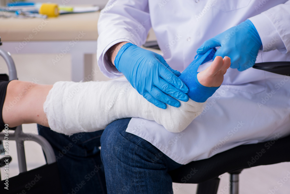 Young leg injured woman visiting old doctor traumatologist Young leg injured woman visiting old doctor traumatologist