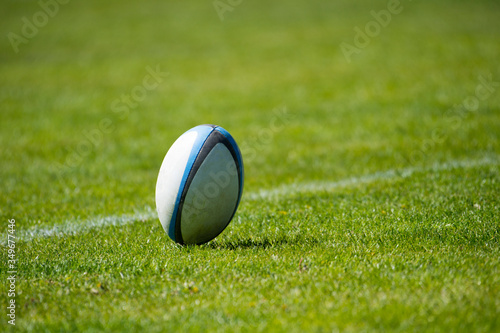 American football, rugby ball on green grass field background..