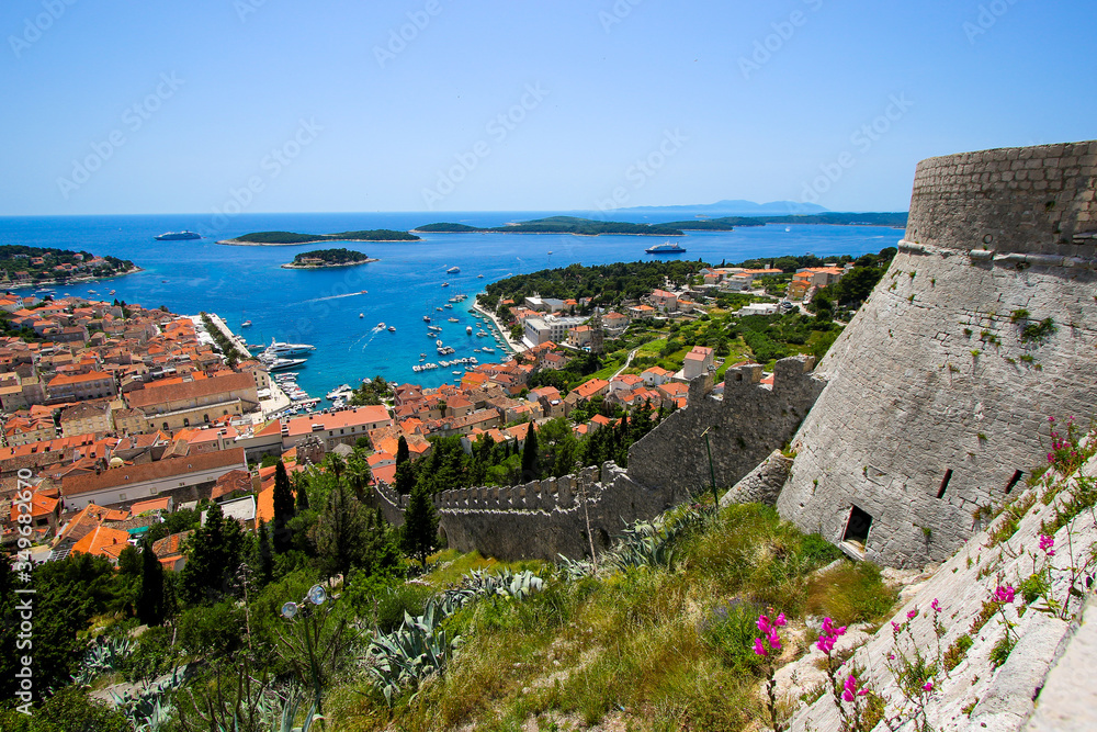 Steep stone wall of the Spanjola Fortress above the village of Hvar with a view over the old port of Hvar on Croatia