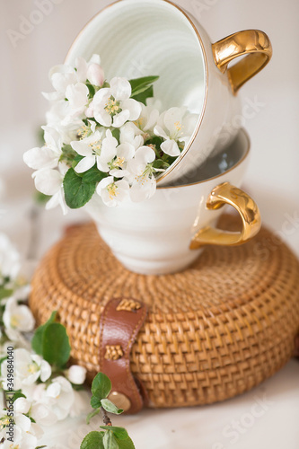 Fotografía Delicate, white flowers of an apple tree in a porcelain cup with a golden handle