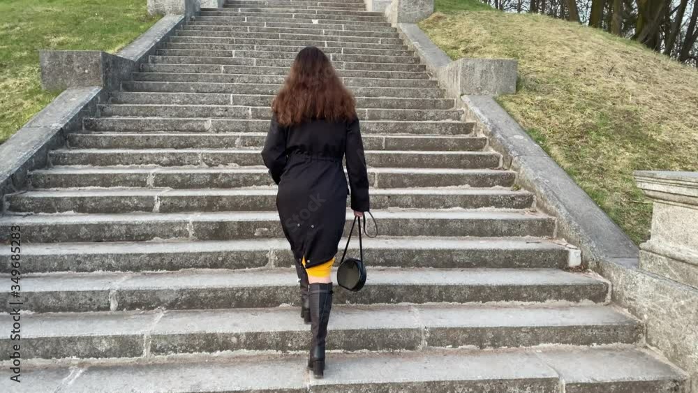 Rear view of woman walking up the stone steps in the park, Marienthal pond and staircase in Pavlovsk park, Saint Petersburg, Russia. Rear view of woman walking up the stone steps in the park, Marienthal pond and staircase in Pavlovsk park, Saint Petersburg, Russia.