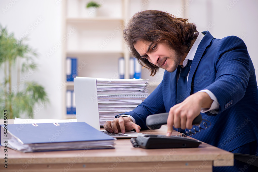 Young male employee unhappy with excessive work Young male employee unhappy with excessive work