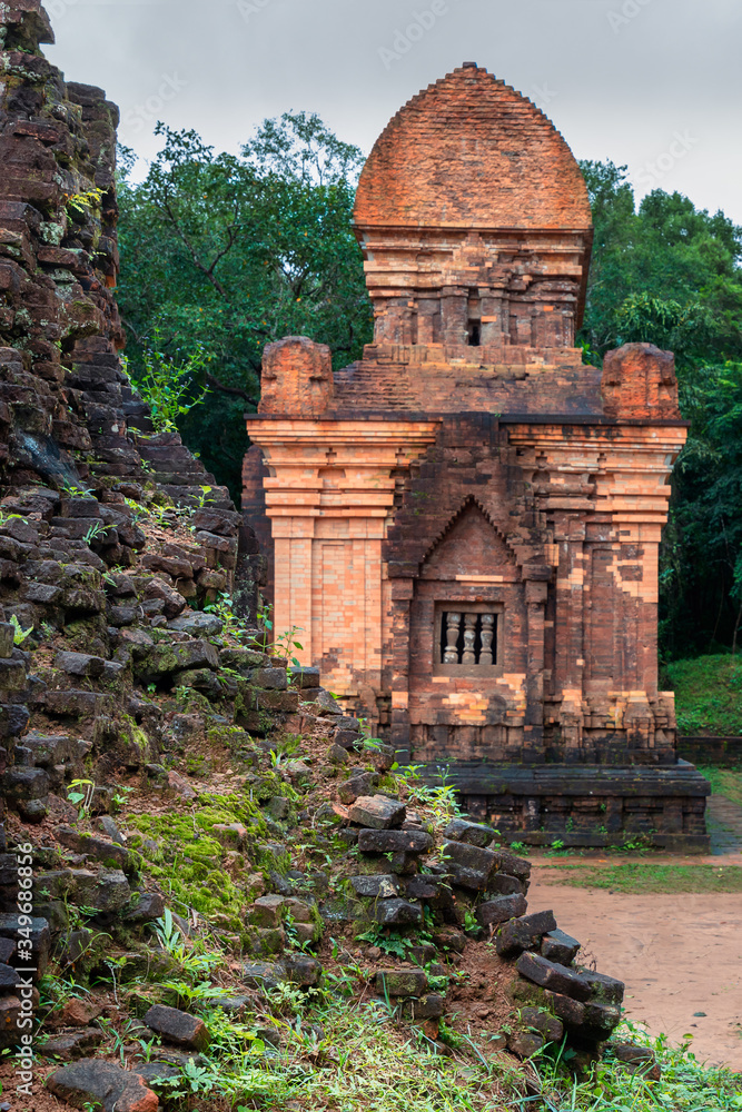 Ruins of ancient temple in front of renovated temple in My Son