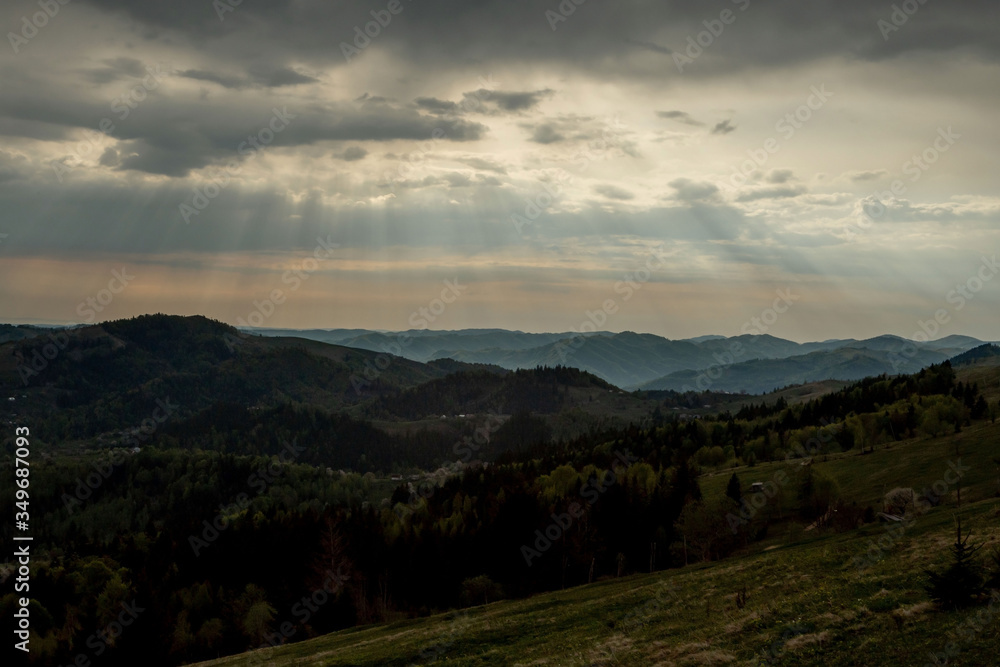 Fototapeta premium Beautiful sunset colors over the mountains of Carpathian, Ukraine, Europe. Sun setting after hot summer day. Photo in orange and blue natural tones.