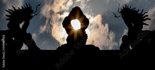 Sun rays passing through silhouette of dragons on temple roof