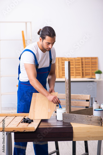 Young male contractor working in workshop