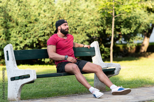 Smiling Handsome Guy Resting on Bench Outdoors