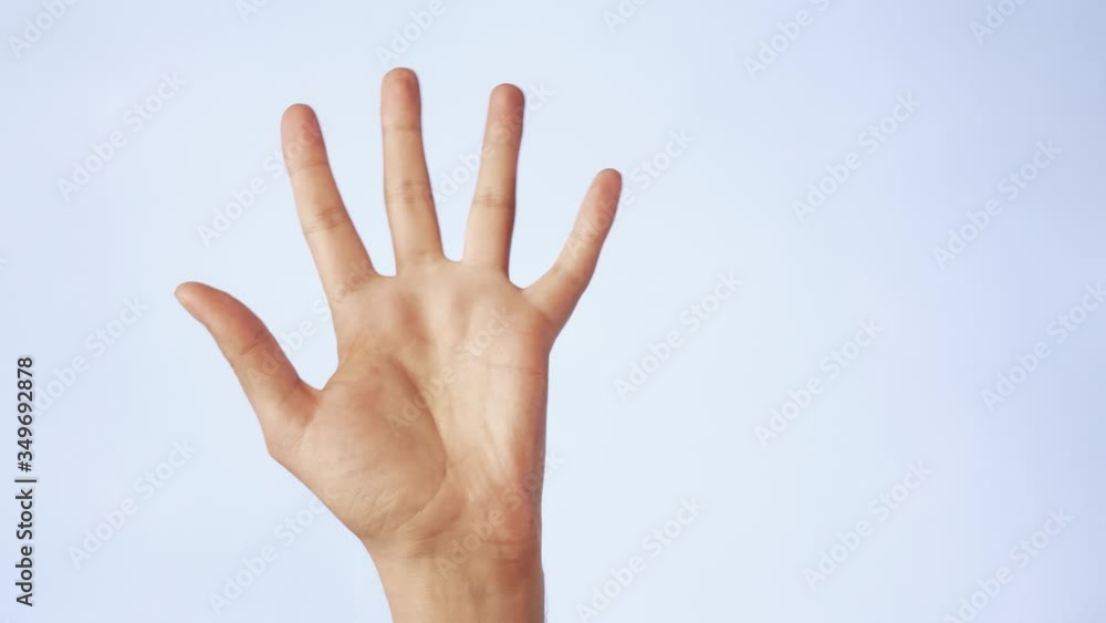 Close up man hand showing palm or high five finger gesture raised isolated on white background Close up man hand showing palm or high five finger gesture raised isolated on white background