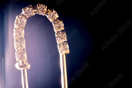 decorative jewelry pin, black background macro low light