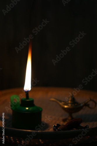 Oil lamp with flaming fire on woven tray with ketupat ornaments photo