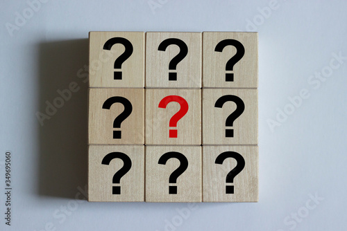 Close-up of wooden cubes in the form of a square with a question mark on them. Business decision making concept.