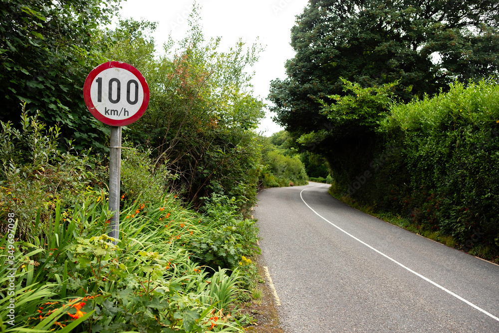 Speed limit 100 kilometers per hour sign A posted Aon country road in Ireland Speed limit 100 kilometers per hour sign A posted Aon country road in Ireland