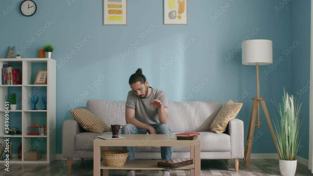 Man stays home, in self-isolation, trying to kill time, drinks coffee and throws dice aimlessly, feeling lonely and depressed, lacking live communication, Slow motion. Man stays home, in self-isolation, trying to kill time, drinks coffee and throws dice aimlessly, feeling lonely and depressed, lacking live communication, Slow motion.