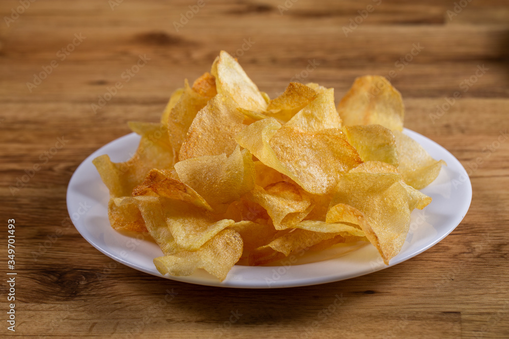 portion of potato chips on wooden background portion of potato chips on wooden background