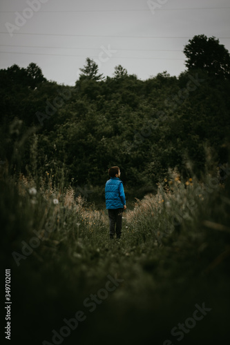 Little boy standing on the nature road and watching sky © Emir