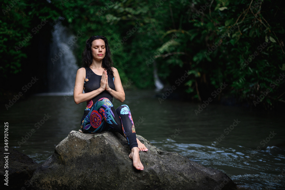 Fototapeta premium Yoga practice and meditation in nature. Woman practicing near river