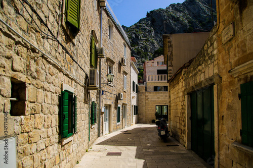 Narrow street in the old town of Omis in Croatia - Stone houses by the mountains on the Makarska riviera