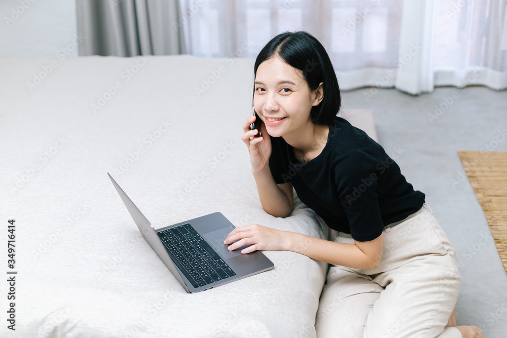 Attractive asian female calling with co-worker while working with laptop. at home Work from home concept. Attractive asian female calling with co-worker while working with laptop. at home Work from home concept.