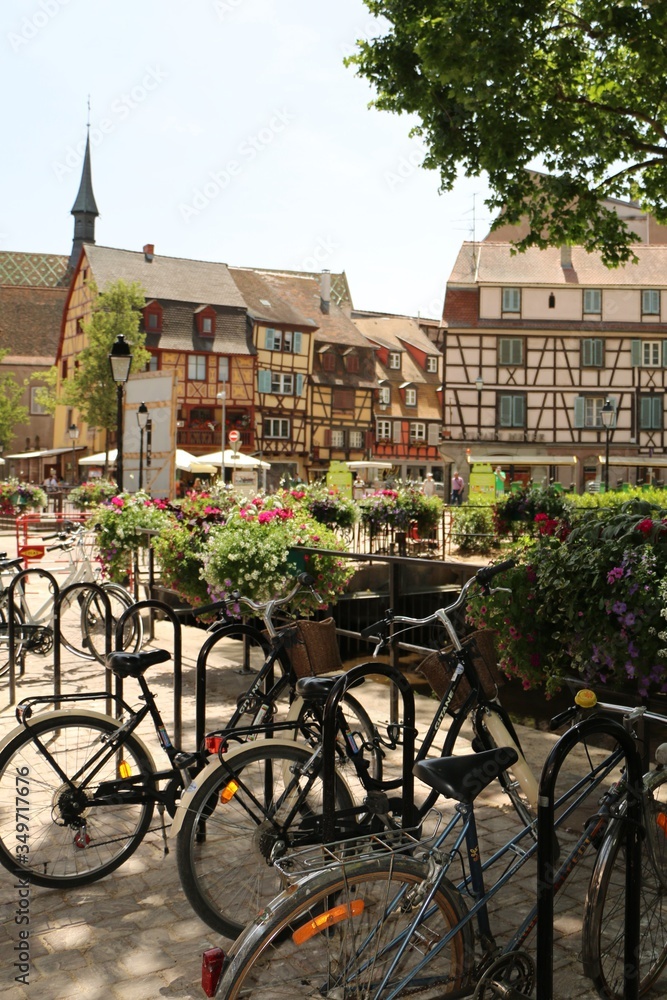 Strasbourg city in France with bicycles in summer with flowers and buildings in the background, all invoking a sense of wonder and adventure. 