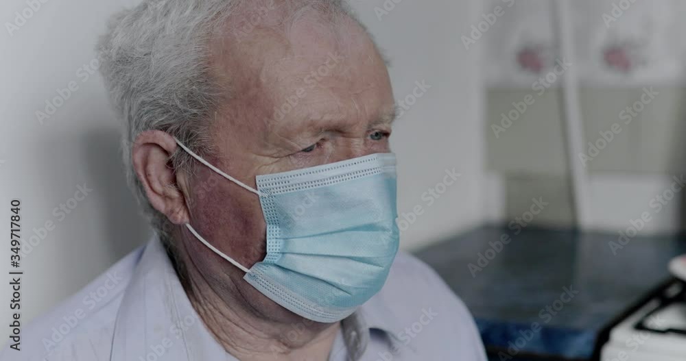 An elderly man with a coronavirus coughs up in a mask and looks at the camera An elderly man with a coronavirus coughs up in a mask and looks at the camera
