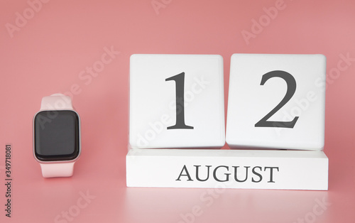 Modern Watch with cube calendar and date 12 august on pink background. Concept summer time vacation.