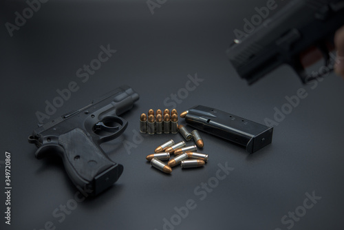Gun with ammunition on iron dark background