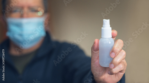 Selective focus a man hand with alcohol gel bottle for cleaning in Covid-19 crisis and health care.