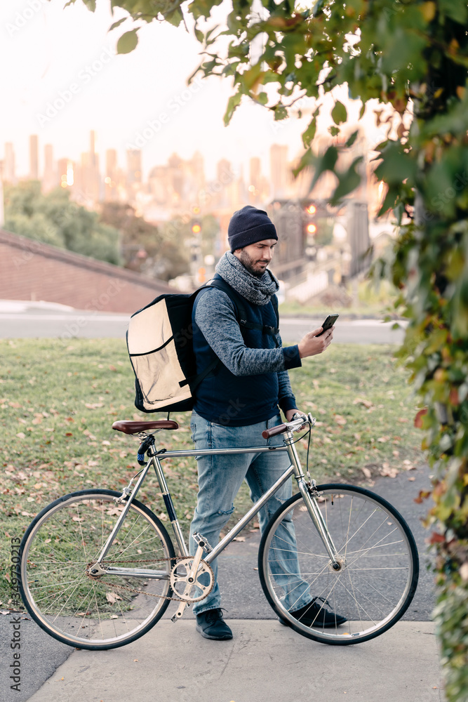 Food delivery rider checks new orders in his smart phone while holding ...