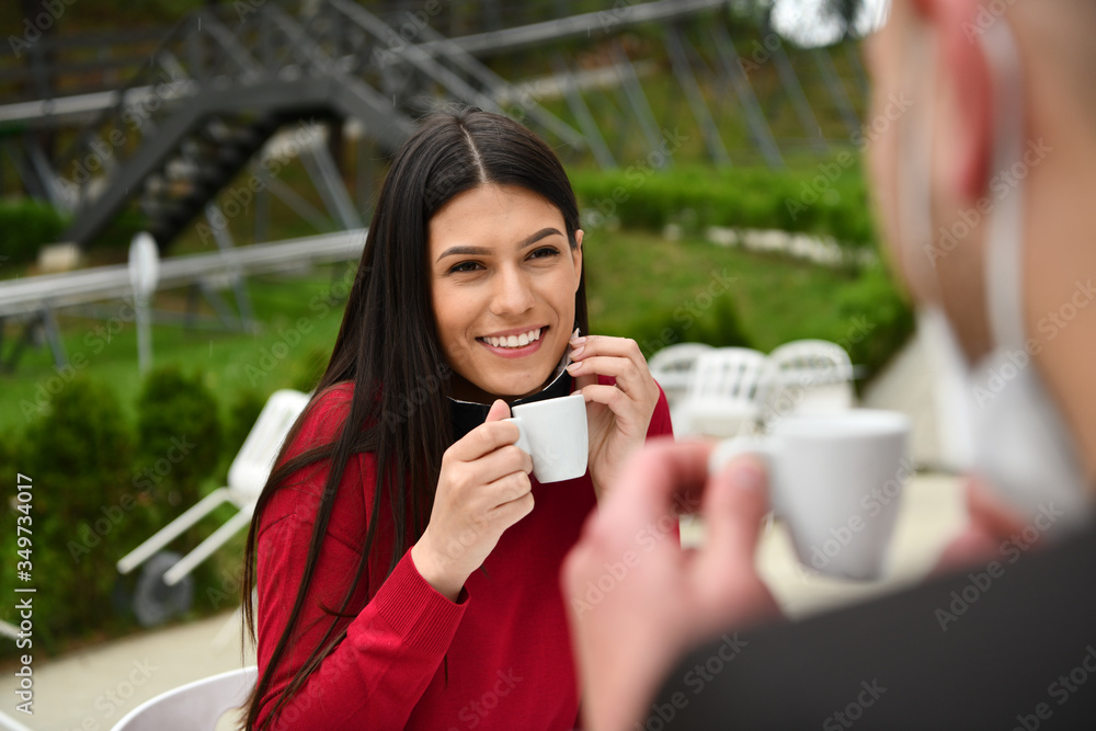 couple with protective medical mask having coffee break in a restaurant couple with protective medical mask having coffee break in a restaurant