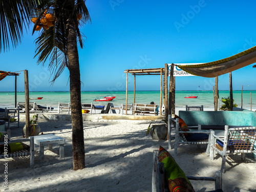 Fishing boats and crystal clear turquoise waters at paje beach village on the island of zanzibar. photo