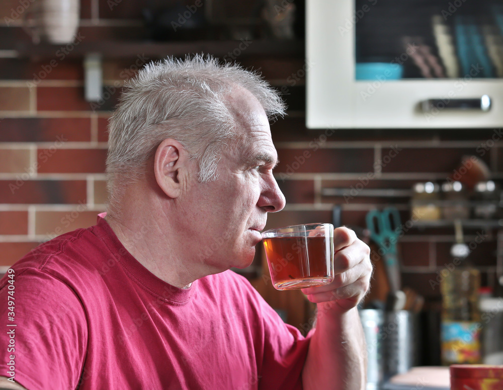 A man drinks tea in the kitchen A man drinks tea in the kitchen