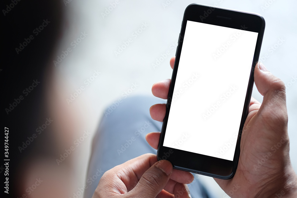 Cropped shot view of man hands holding smart phone with blank copy space screen for your text message or information content, female reading text message on cell telephone during in urban setting. 