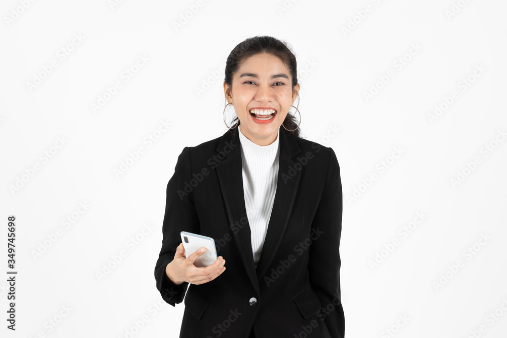 Smiling happy young Asian business woman in suit holding mobile smart phone over white isolated background. Smiling happy young Asian business woman in suit holding mobile smart phone over white isolated background.
