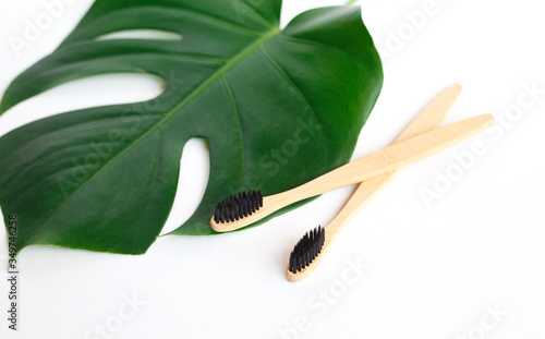 The concept of zero waste. bamboo toothbrush on a manstera leaf photo