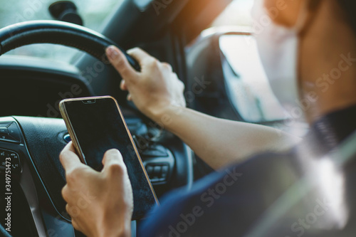 woman driving a car and using smartphone .