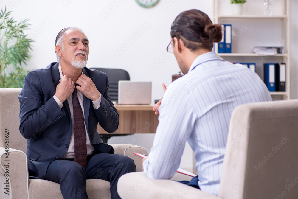 Old man visiting young male doctor psychologist Old man visiting young male doctor psychologist