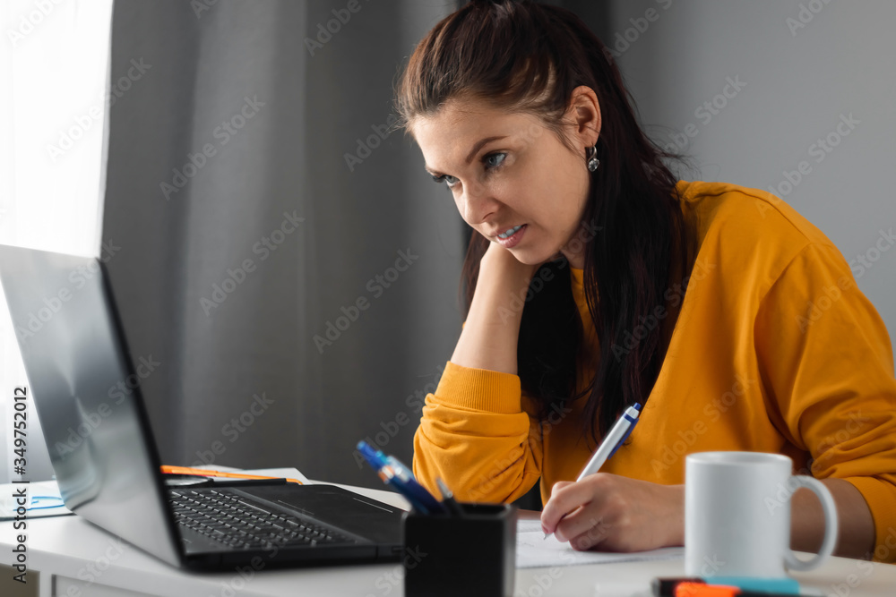 Beautiful girl using laptop working at home, concept of online work, remote work. Watching a webinar, looking for friends on social networks. Modern technologies. Beautiful girl using laptop working at home, concept of online work, remote work. Watching a webinar, looking for friends on social networks. Modern technologies.