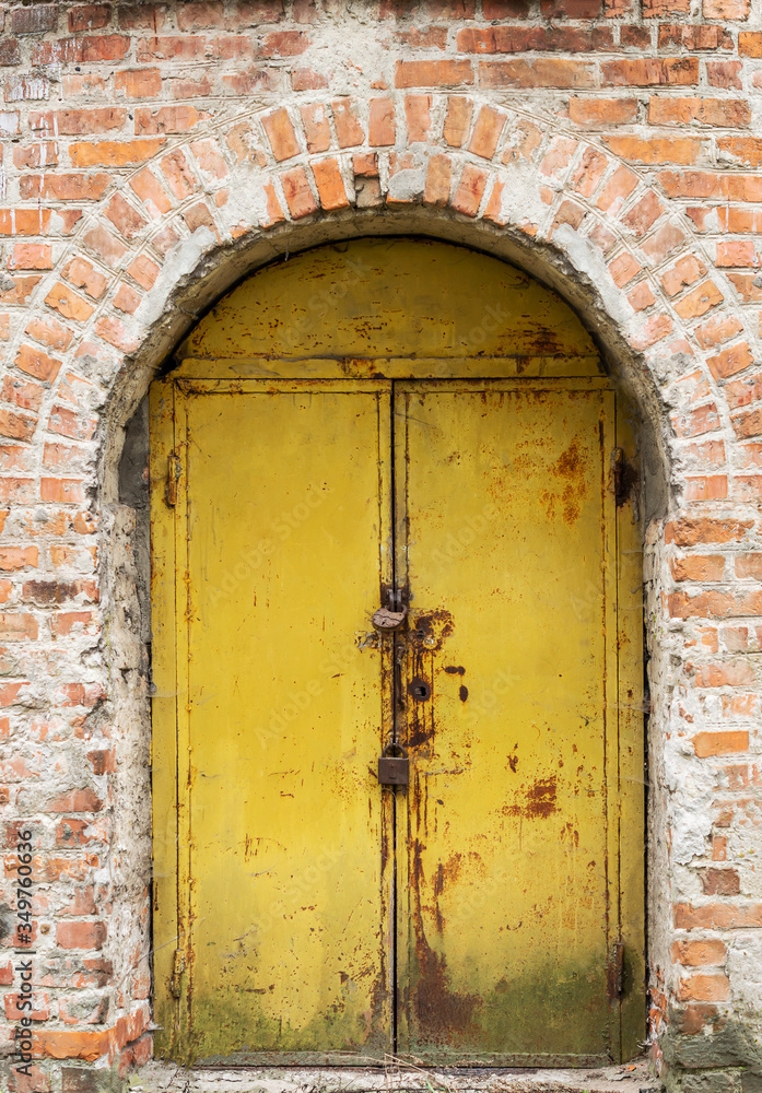 Old rust metal door in brick wall.