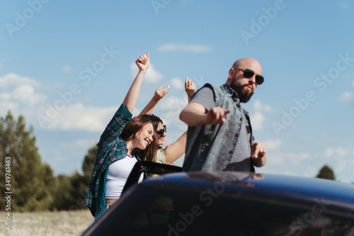 Car traveling. Group of friends enjoying vacation together. Road trip, sightseeing, friendship